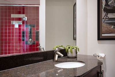 Bathroom with vanity, shower area & large mirror in Queen Premiere at Retro Suites Hotel