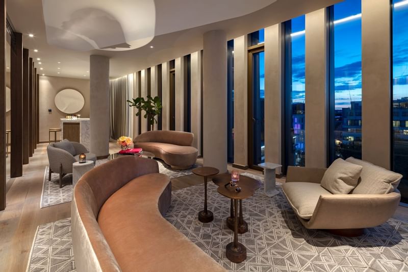 Living area with plush blue sofas and unique coffee tables in Tower Penthouse Suite at The Londoner Hotel