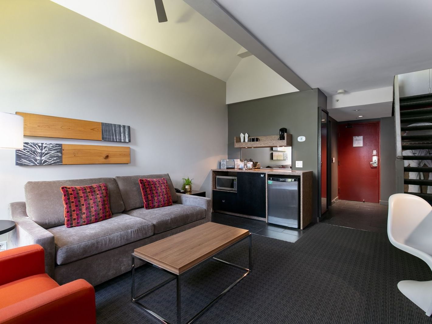 Broad living space in hotel room with kitchenette.