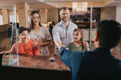 Family checking-in by the front desk at Hotel Coral y Marina