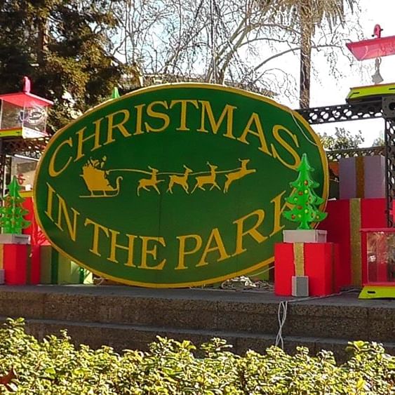 Christmas In the Park Sign decorated with fake presents and trees around the sign