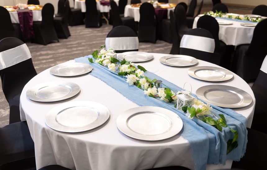 Elegant wedding banquet table featuring a light blue runner and silver plates at Rodd Grand Yarmouth