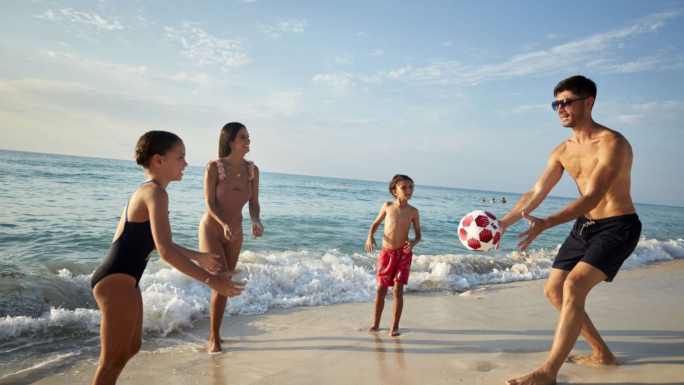 Group of people playing soccer on the sandy beach near Fiesta Americana