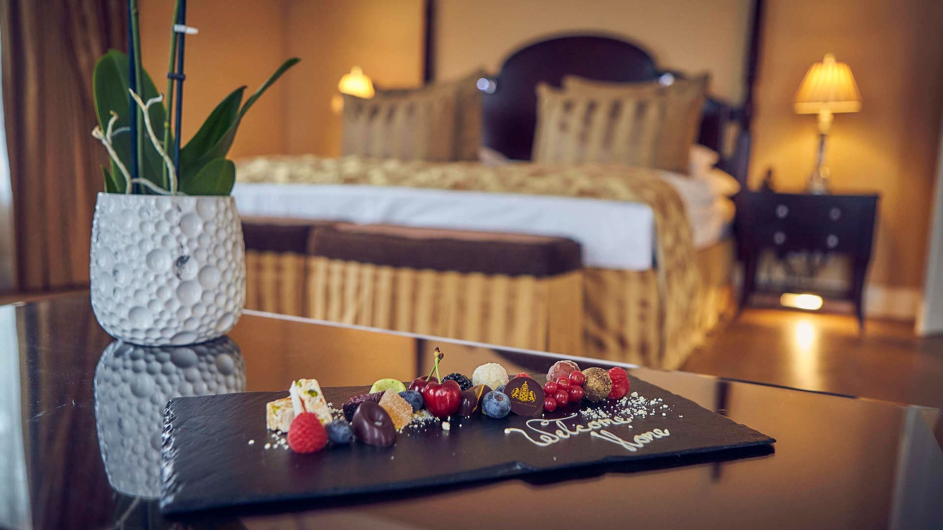 Sweet treats arranged on a table by the bed at Falkensteiner Schlosshotel Velden