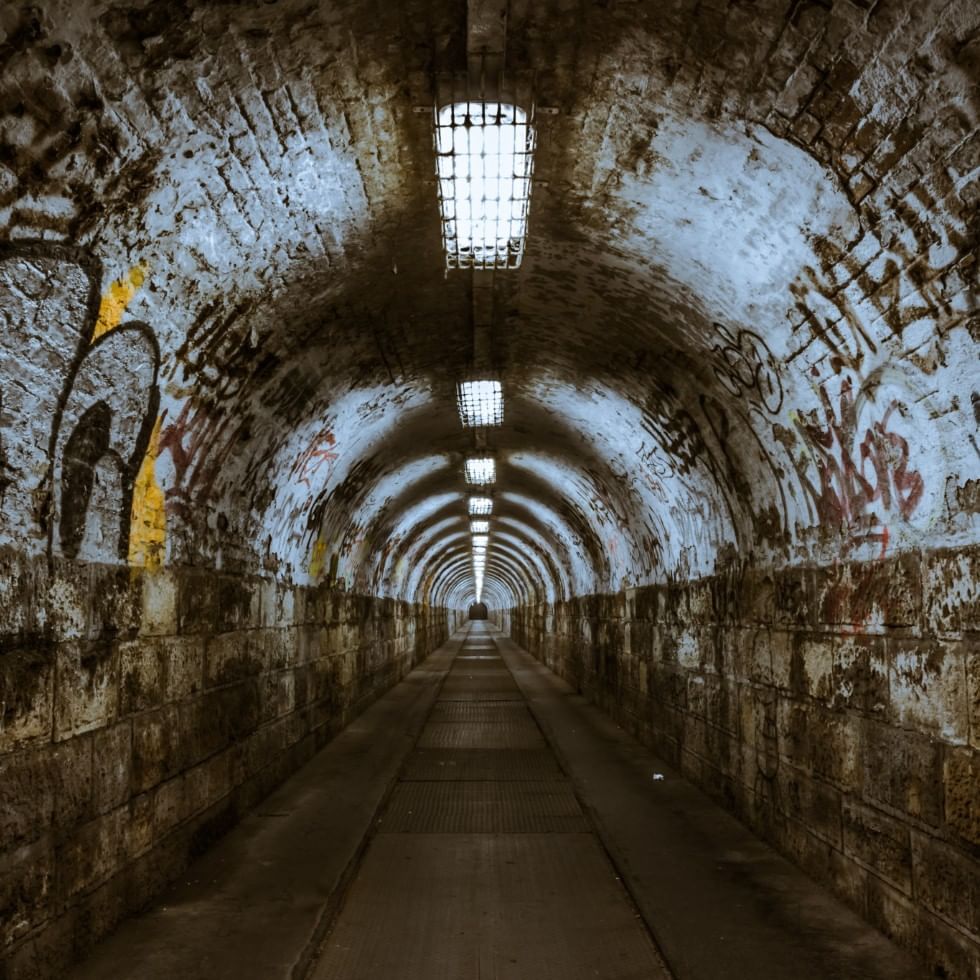 A tunnel with writings on the walls near Falkensteiner Hotels