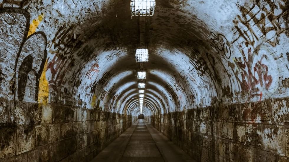 A tunnel with writings on the walls near Falkensteiner Hotels