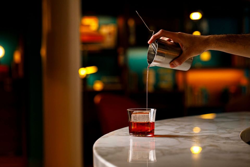 A bartender pouring an Italian wine into a glass at Portico84