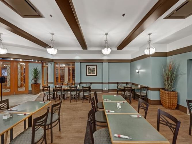 Dining table arrangements with chandeliers in Carving Board Dining Room at The Glenmore Inn & Convention Centre