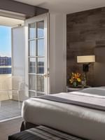 White balcony chair by a glass door in a guestroom with a wood wall in Executive Suites at Warwick Denver