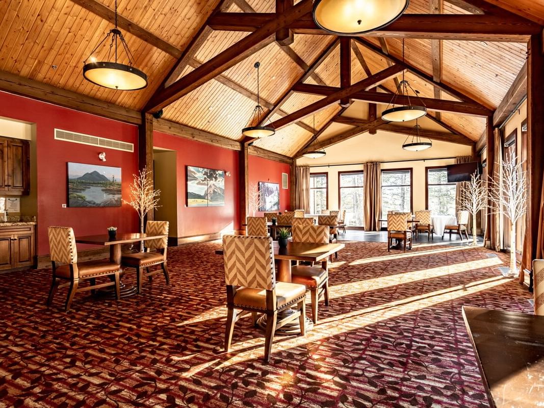 Dining tables are arranged in The Clubhouse in Stewart Creek near Blackstone Mountain Lodge