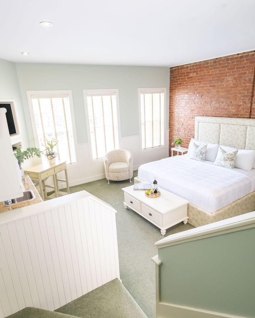 Elevated view of the bedroom with brick wall, work desk & furniture in Premiere Loft Nantucket at Retro Suites Hotel