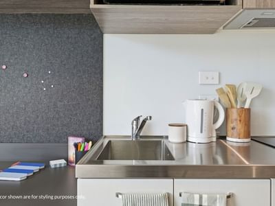 Modern kitchen area with sink, electric kettle, and utensils at Mayoral Drive Student Accommodation.