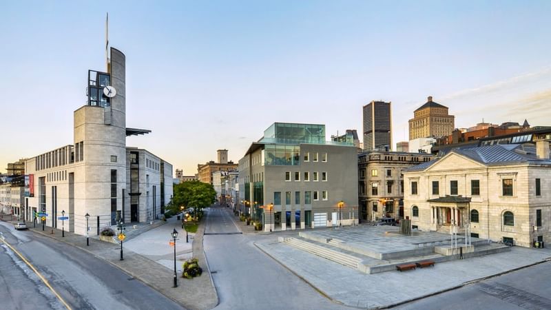 Montreal urban plaza with modern clock tower and historic buildings at Warwick Le Crystal Montreal