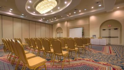 banquet room with rows of chairs and projector