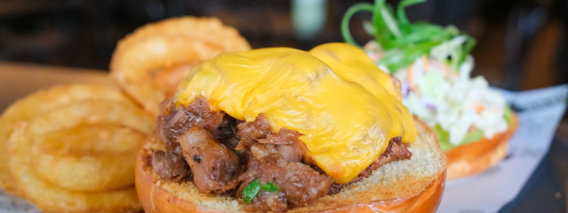 Delicious meat slider topped with melted cheese and served with crispy onion rings at Novotel Perth Langley