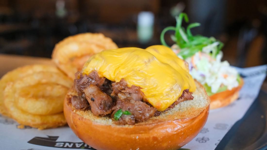 Delicious meat slider topped with melted cheese and served with crispy onion rings at Novotel Perth Langley