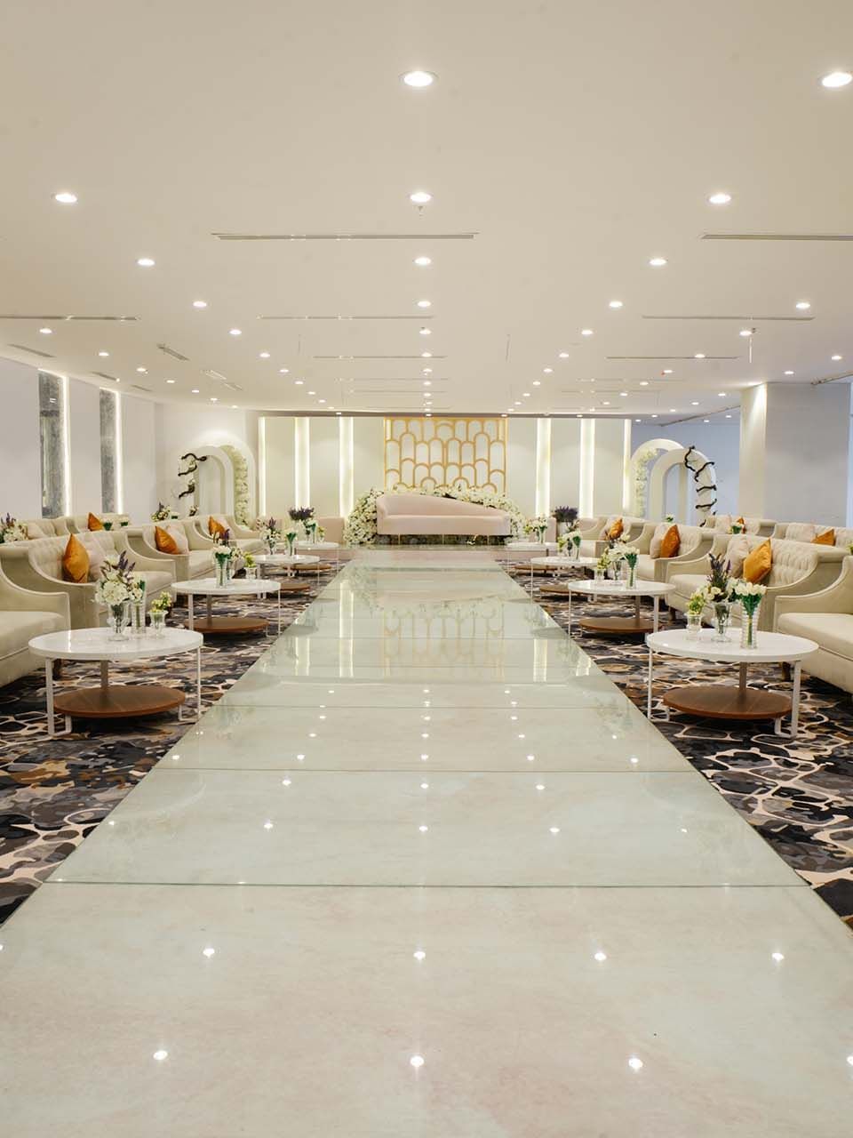 Cream sofas with orange pillows surrounding a polished in Crystal Ball room at Cantonal Hotel by Warwick Riyadh