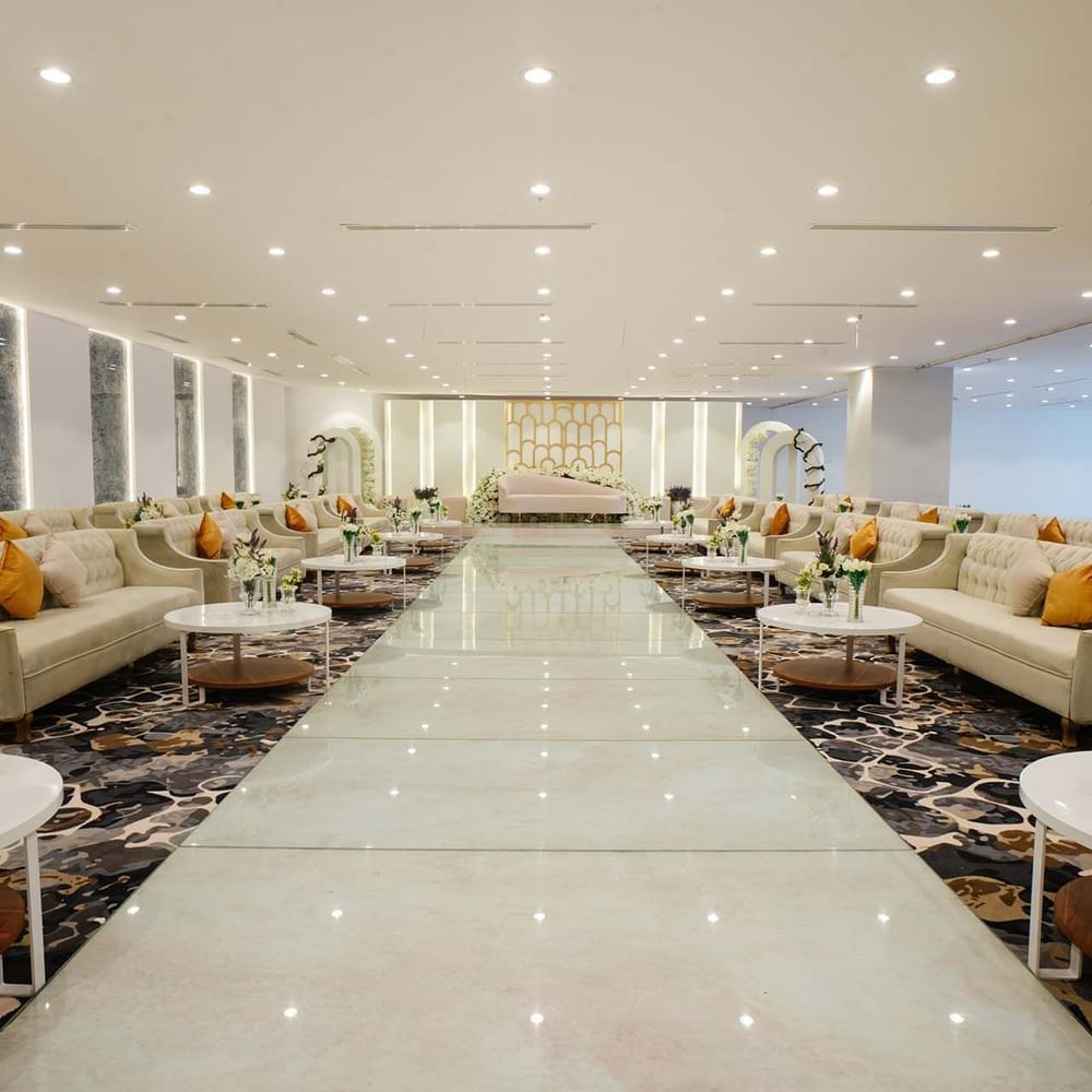 Cream sofas with orange pillows surrounding a polished in Crystal Ball room at Cantonal Hotel by Warwick Riyadh