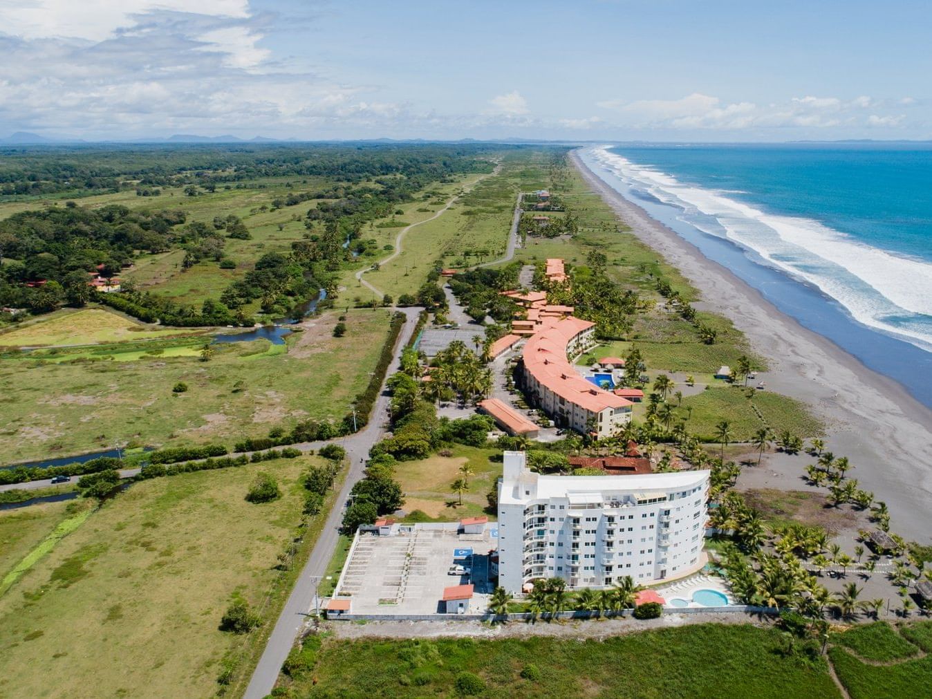 Aerial view of Las Olas Towers Oceanfront and Oceanview Apartments with a long beach at Las Olas Beach Resort