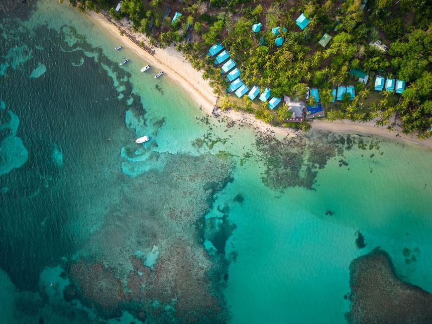 Aerial view of the stunning La Zebra Hotel beachfront property along the rocky coastline and turquoise ocean