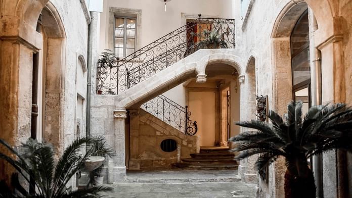 Escalier à l'intérieur d'un bâtiment entouré de palmiers aux Hôtels Oceania