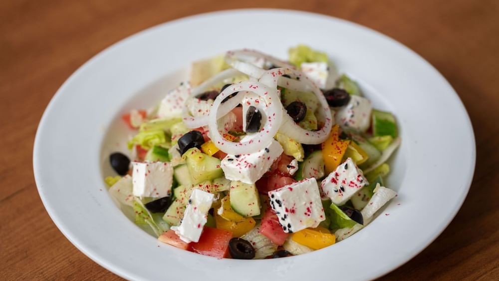Fresh salad featuring diced cucumber, onion rings, and feta cheese in Seasons Restaurant at Warwick Hotel Jeddah