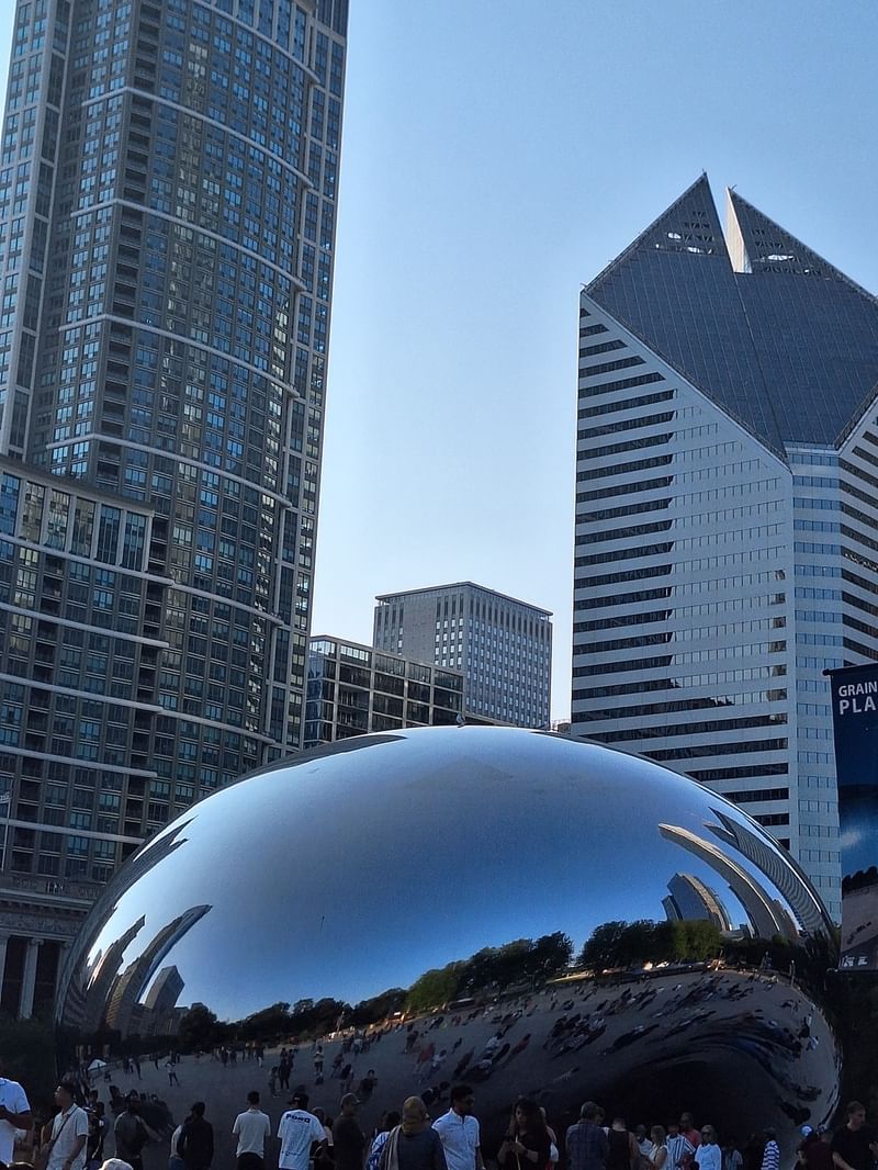 Millennium Park with a large reflective sculpture and many people at the center.
