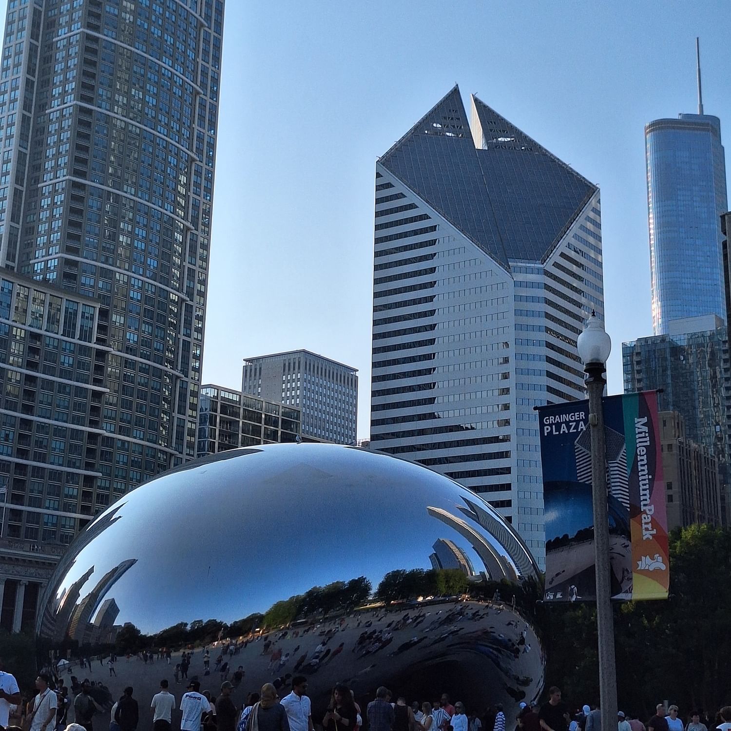 Millennium Park with a large reflective sculpture and many people at the center.