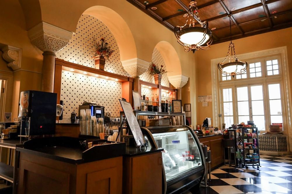 Coffee counter by a display case under hanging lamps in the Venetian Dining Room at Arlington Resort Hotel & Spa