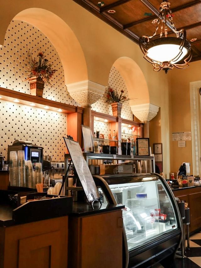 Coffee shop with a pastry case under arched ceilings by hanging lights at the Arlington Resort Hotel & Spa