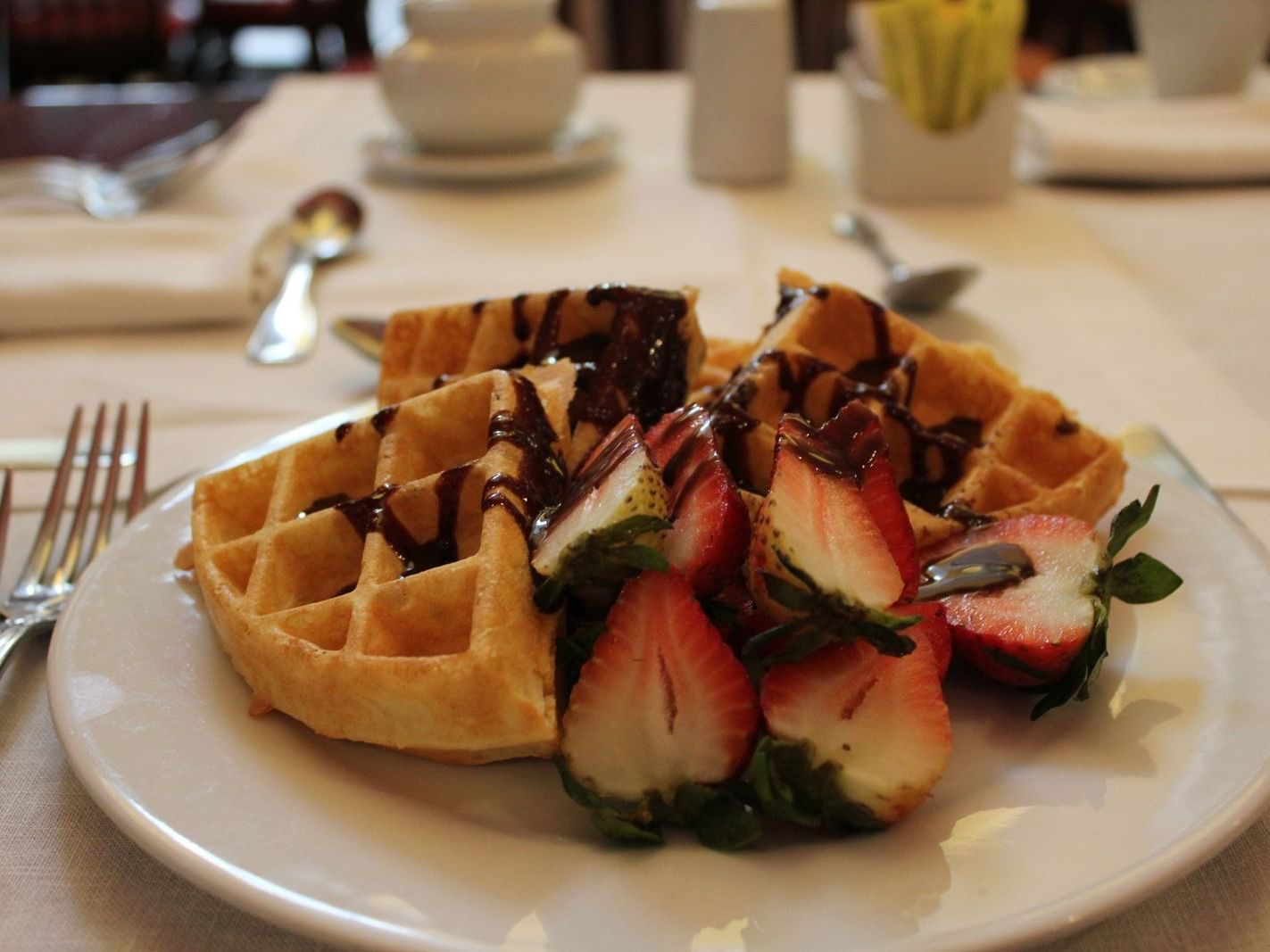 waffles and strawberries drizzled with chocolate 