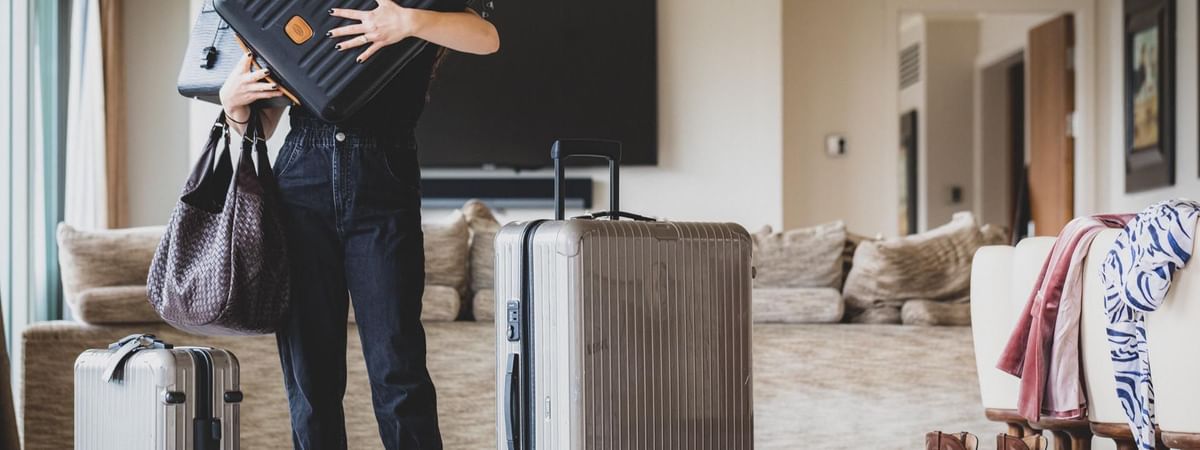Woman balancing luggage over her head in a May Fair bedroom