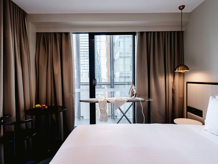 Iron & ironing board by the bed in guest room at Brady Hotels Jones Lane