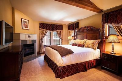 King-size bed by the window with a TV in One King Bed at The Chateaux Deer Valley