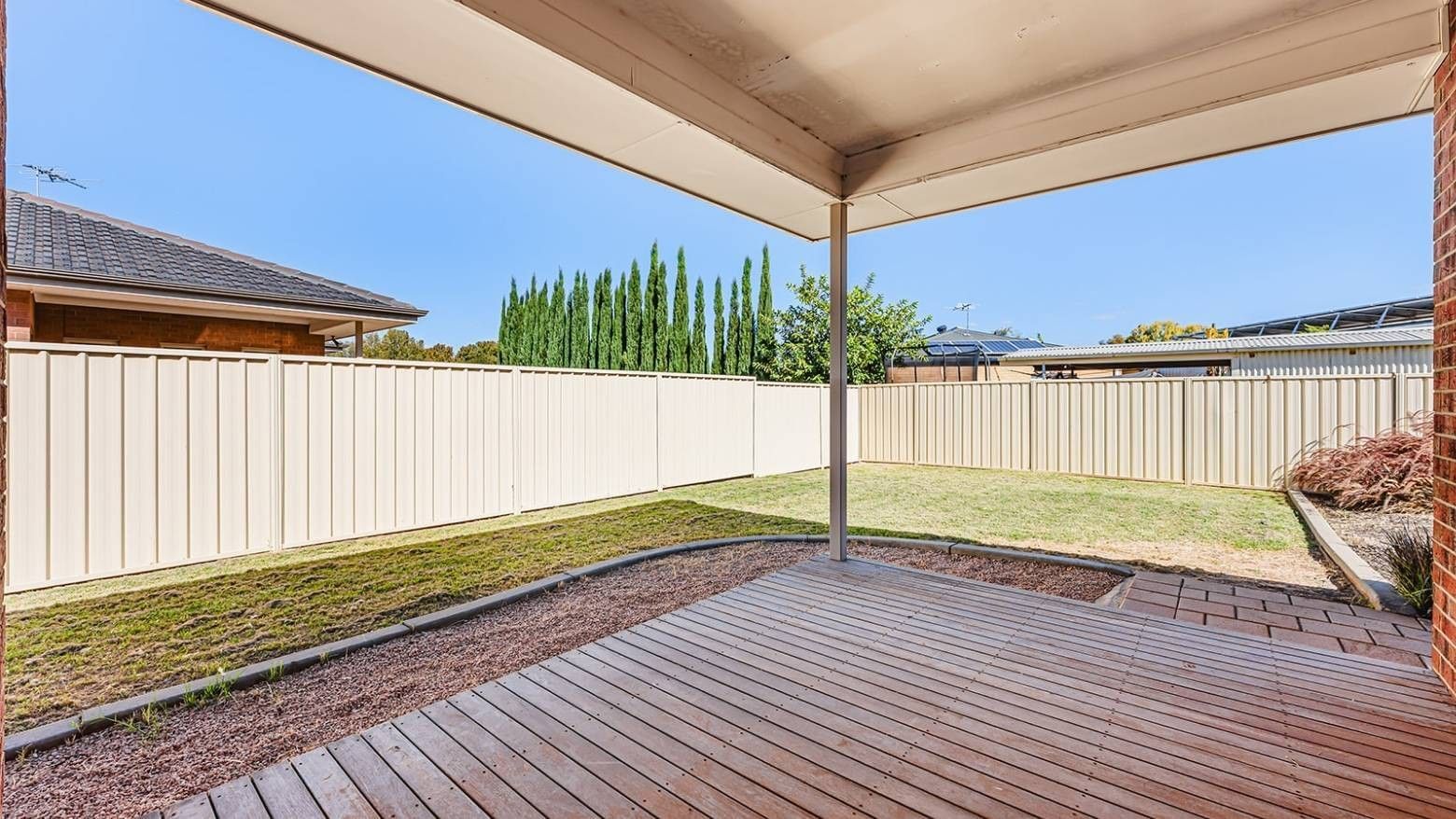 Wooden deck with an open roof and a fenced backyard at La Trobe University Regional Housing Mildura.