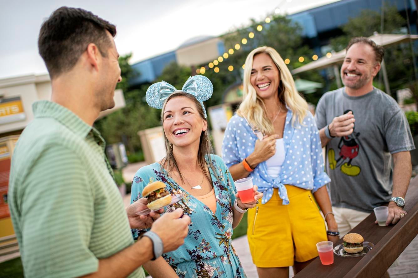 Two couple enjoying food in Disney World’s EPCOT near Lake Buena Vista Resort Village & Spa