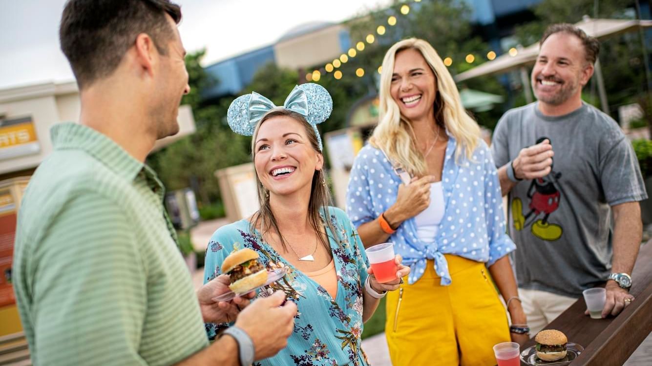 Two couple enjoying food in Disney World’s EPCOT near Lake Buena Vista Resort Village & Spa