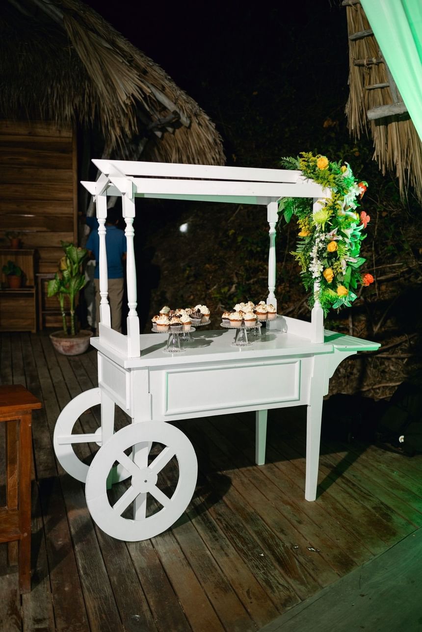 White dessert cart under floral decor on a deck at Morgan's Rock, a sustainable jungle lodge near San Juan del Sur