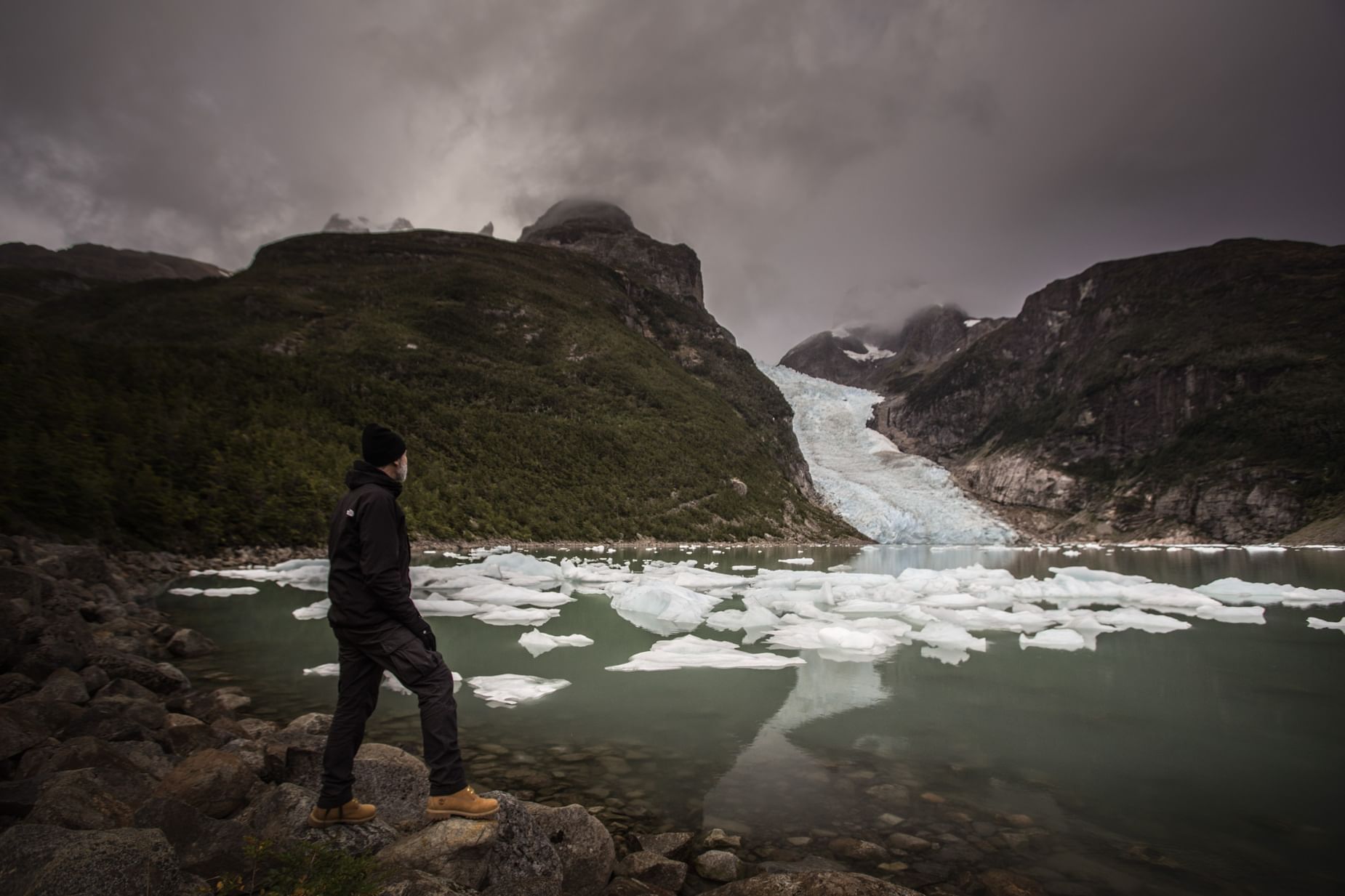 A man at coast watching glaciers near The Singular Patagonia