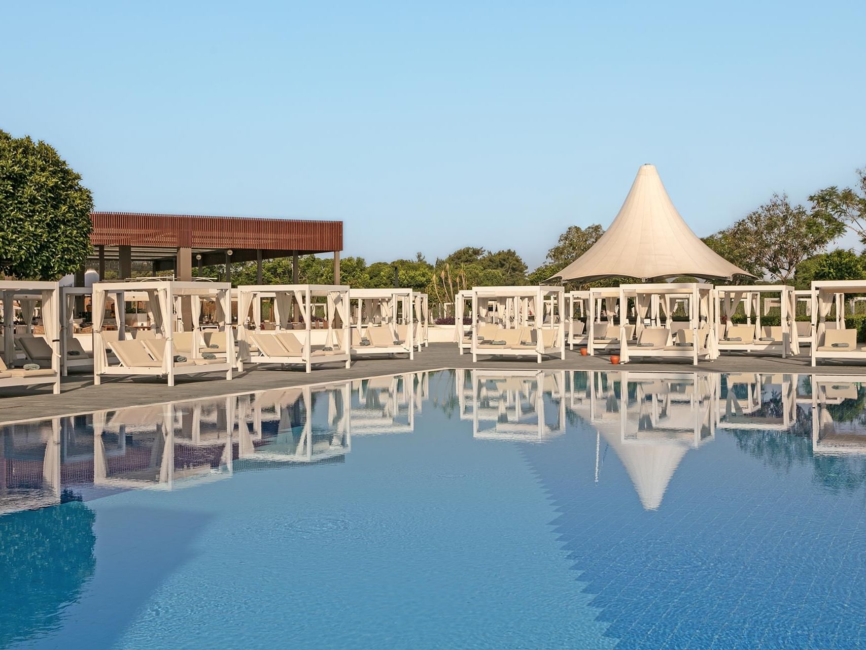 Cozy sun loungers arranged by the outdoor pool at Titanic Deluxe Golf Belek