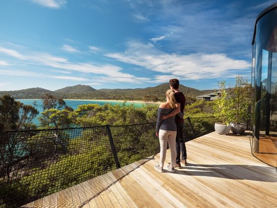 Couple enjoy a scenic view from a balcony at Strahan Village