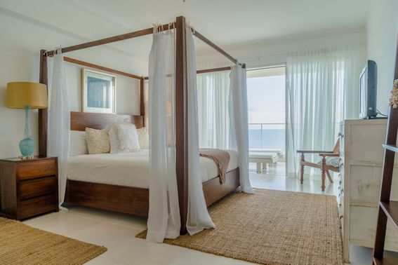 A canopy bed with sea view balcony in suite at Club Hemingway