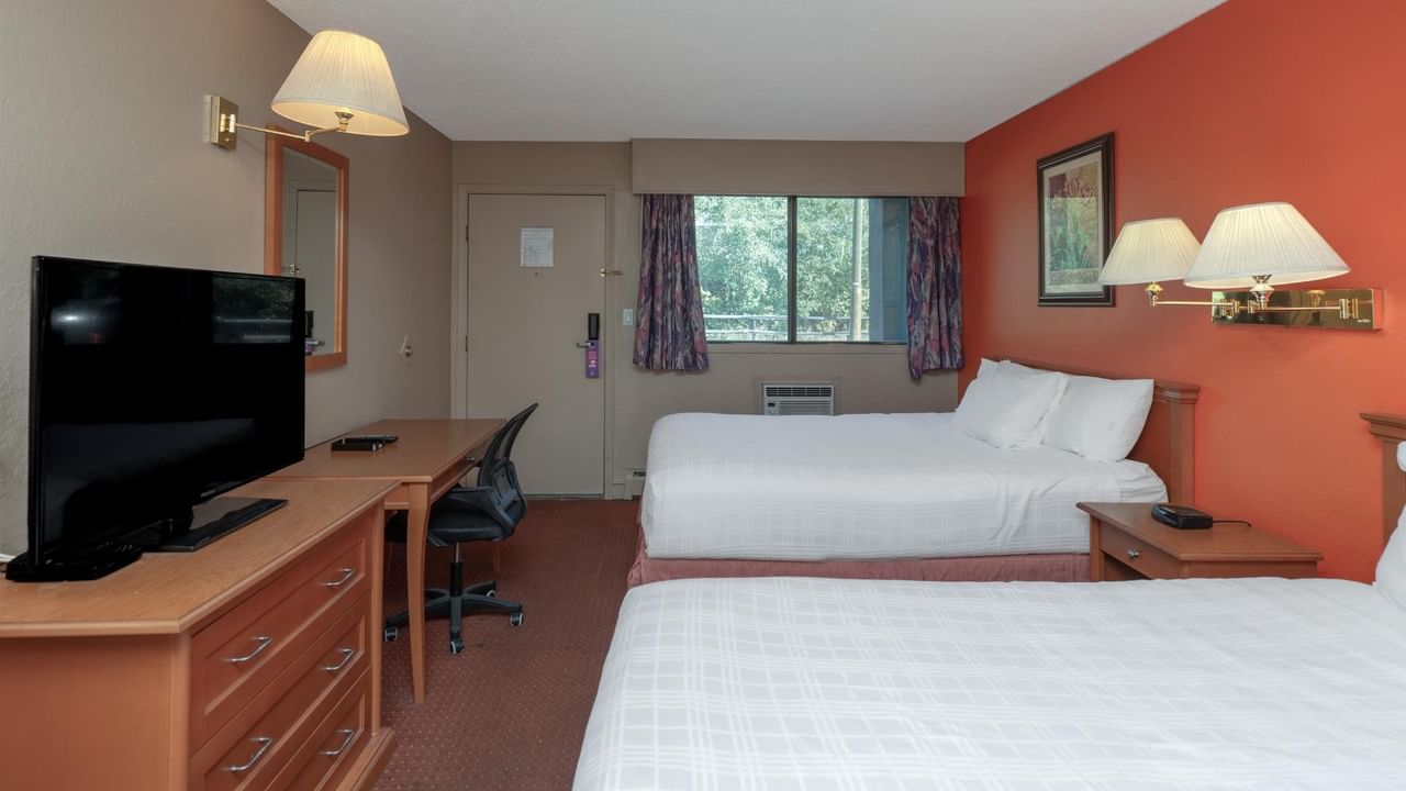 Guest room at Coast Red Deer Hotel with two queen beds, desk and TV