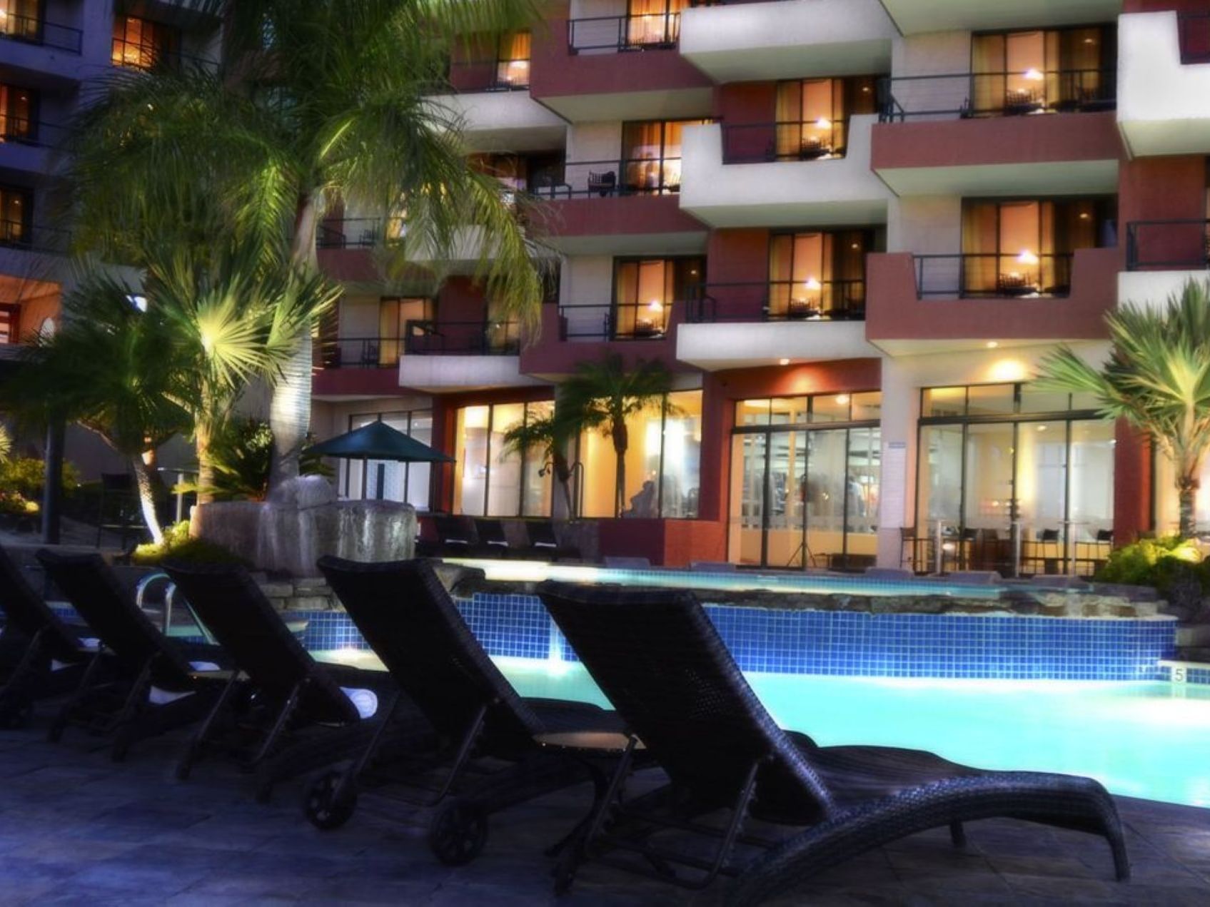 Loungers by the outdoor pool at night at Hotel Coral y Marina