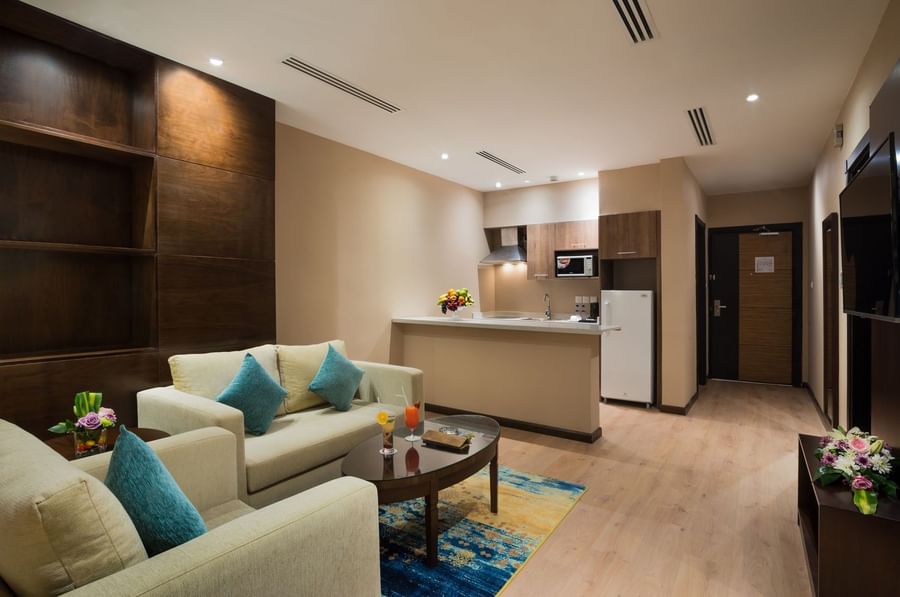 Living area with plush sofa near the kitchenette counter in the Family Suite at Naviti by Warwick Dammam