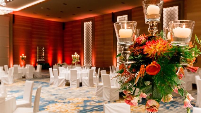 Bankette mit Blumendekoration und brennenden Kerzen im Hochzeitssaal des Titanic Chaussee Berlin.