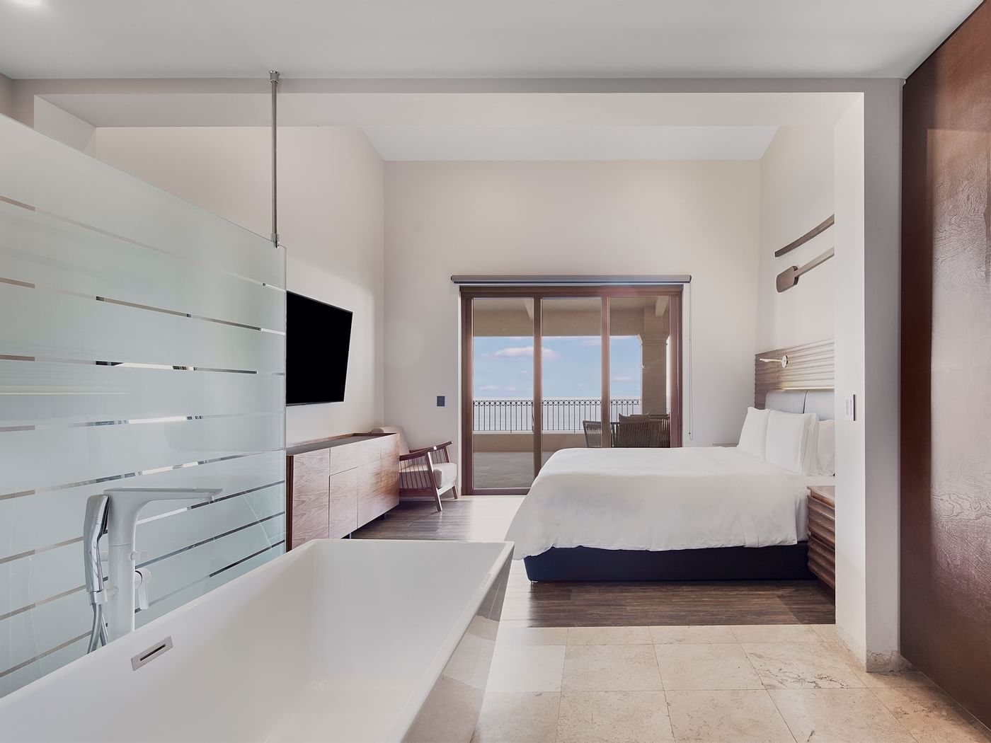 King bed and bathroom vanity in Three Bedroom Residence at Live Aqua Resorts