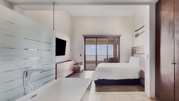 King bed and bathroom vanity in Three Bedroom Residence at Live Aqua Resorts