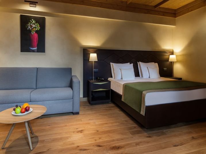 Bed and Sofa with wall art in King Studio at Ana Hotels Bradul Poiana Brașov