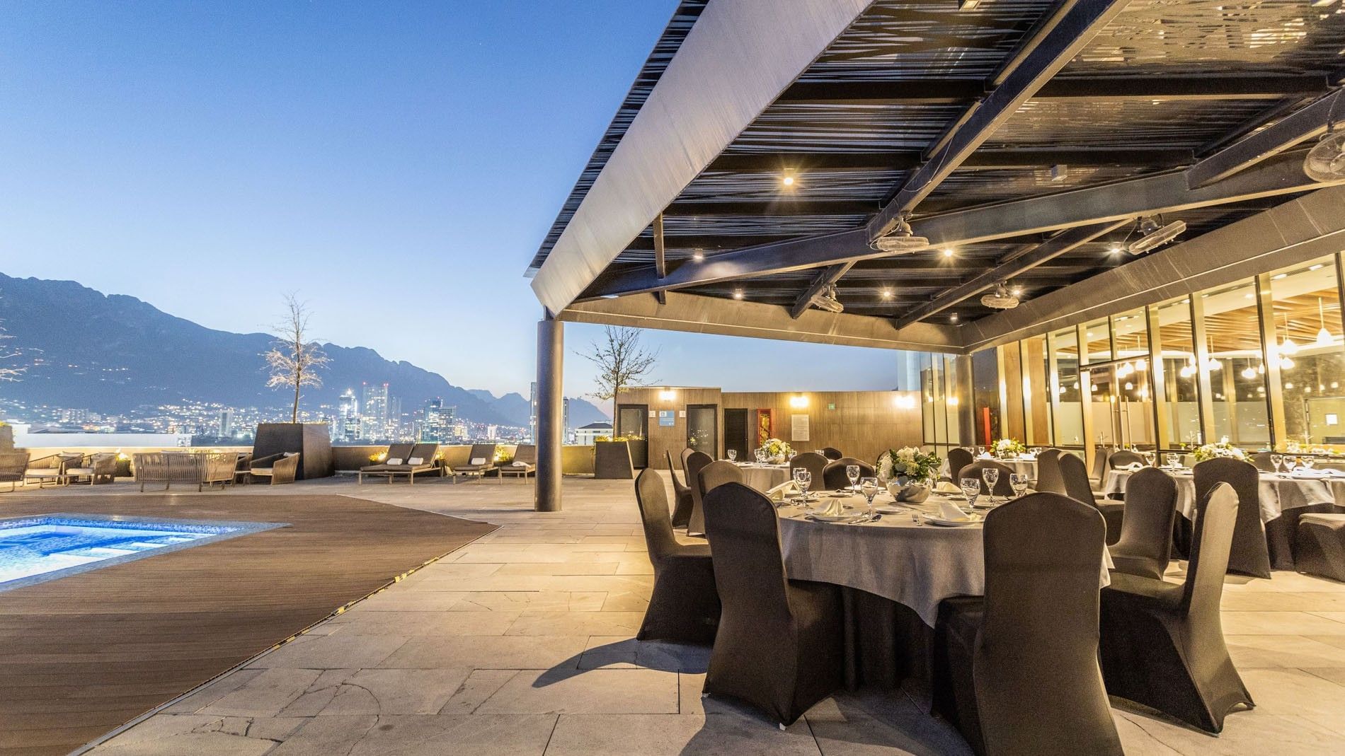 Outdoor event space with dining tables and a pool at Camino Real Fashion Drive Monterrey.